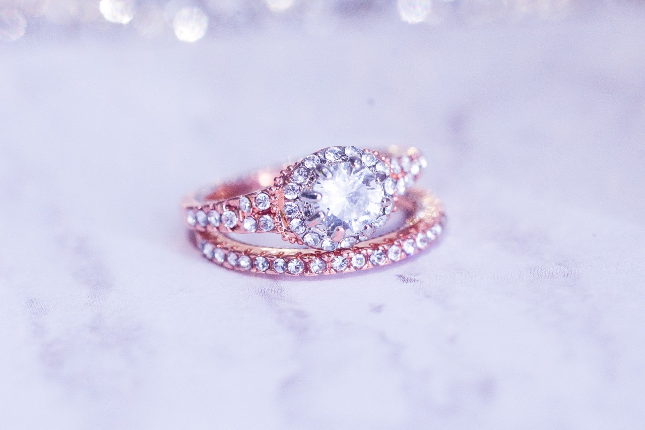 A rose gold diamond side stone engagement ring and eternity wedding band