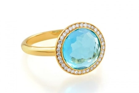 This yellow gold ring features a topaz center stone with a diamond halo