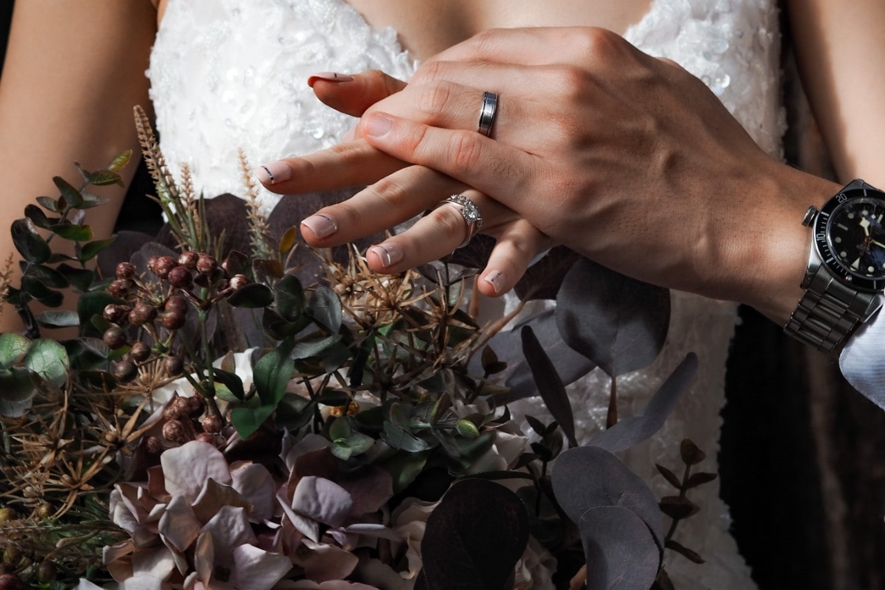 A close-up of a bride-to-be holding hands with her intended.