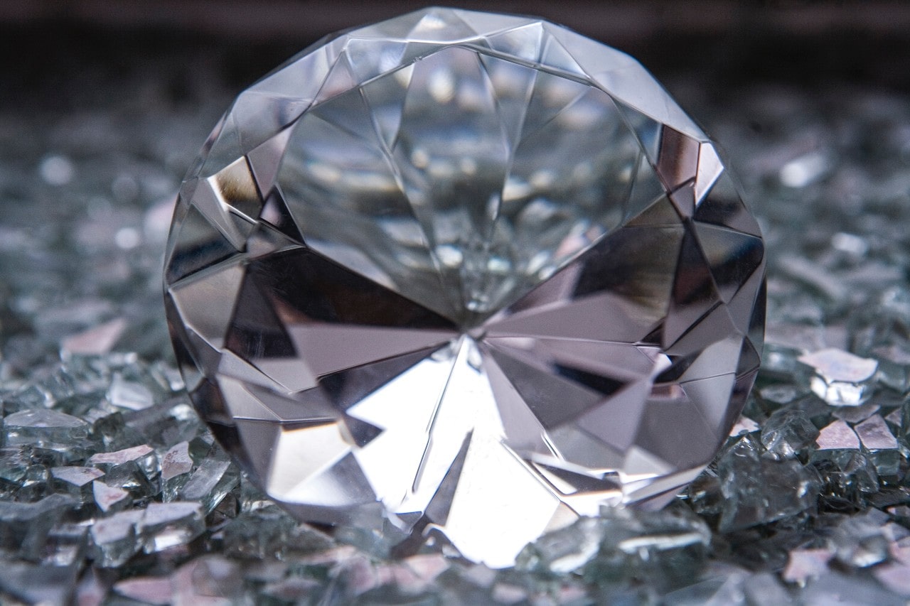 close up image of a round cut diamond sitting amidst diamond shavings