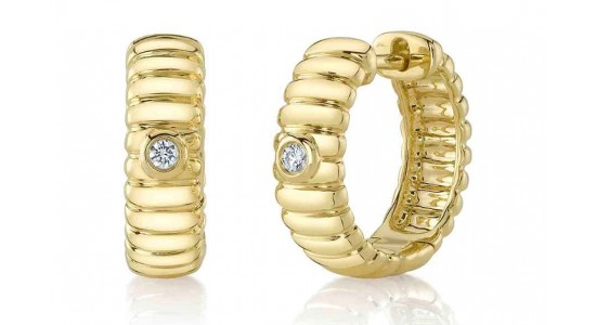 a pair of chunky yellow gold huggie earrings with diamond details