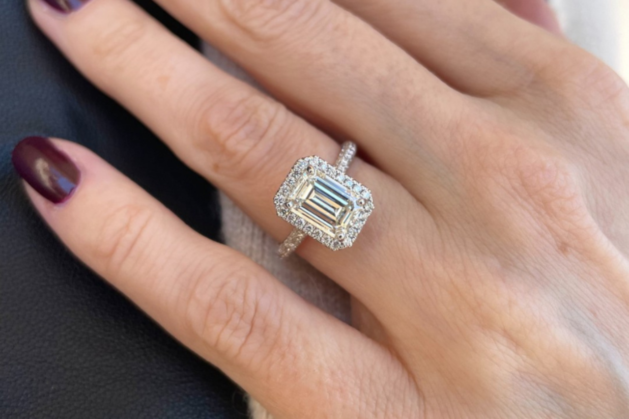 a bride placing her fingers on her chin and wearing an engagement ring between two bands a bride placing her fingers on her chin and wearing an engagement ring between two bands