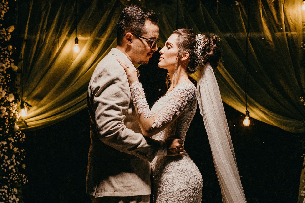 a bride and groom embracing with a dimly lit background