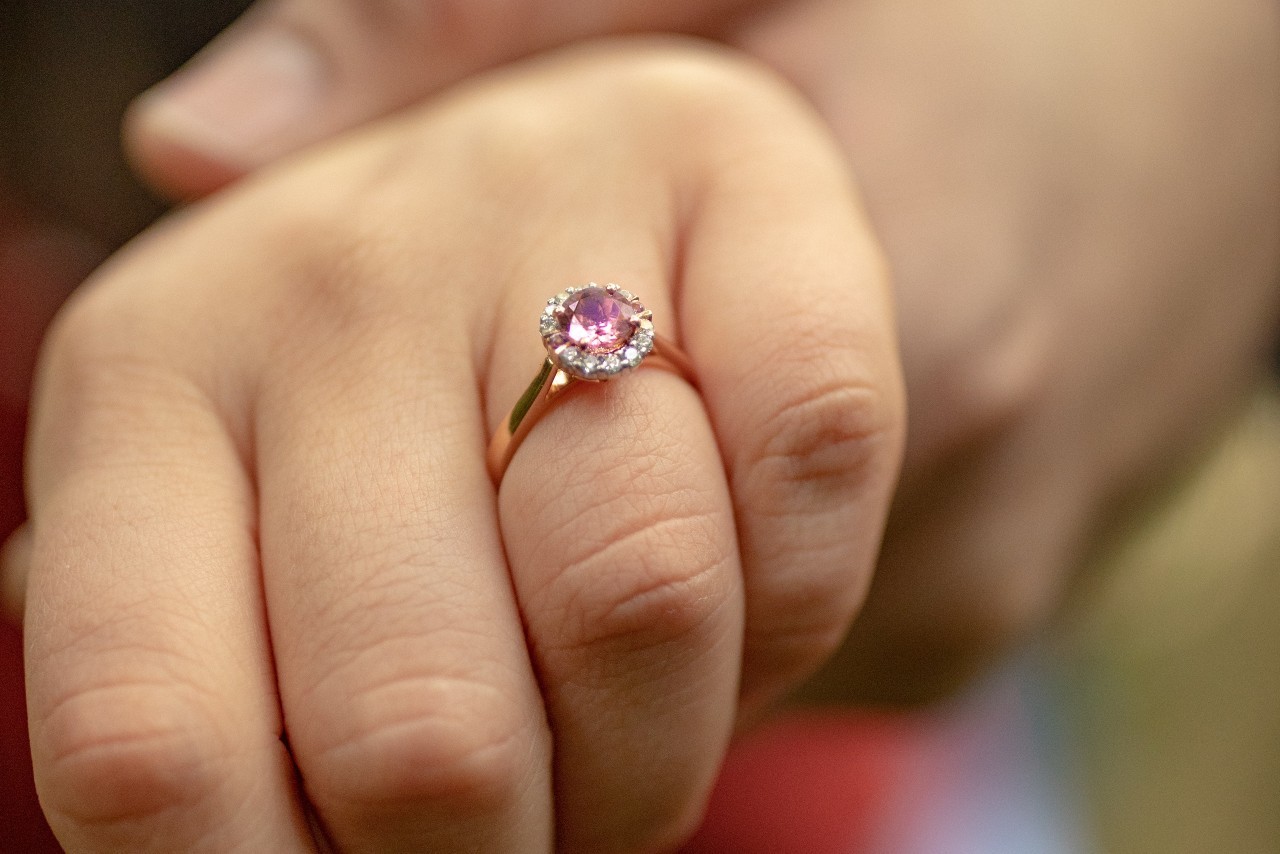 a woman’s hand wearing a rose gold diamond engagement ring