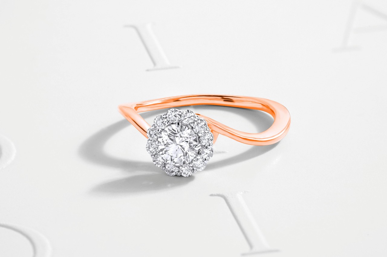 a rose gold diamond engagement ring with a white-lettered background